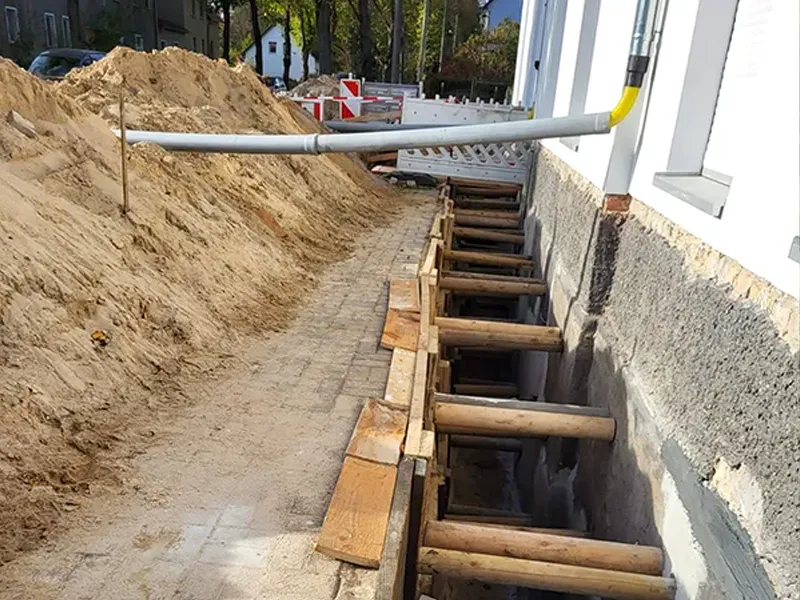 abgestütze Hauswand mit Entwässerungsrohr
