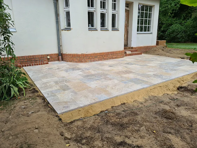 neu angelegte, gepflasterte Terrasse vor Neubau